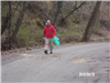 Man Walking down Road with a Bag